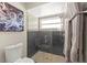 Modern bathroom featuring an octopus art piece and a glass-enclosed shower with gray tiles at 15917 Hidden Lake Cir, Clermont, FL 34711
