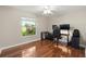 Spacious bedroom features wood floors and a large window with natural light, perfect for an office space at 15917 Hidden Lake Cir, Clermont, FL 34711