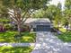 Well-manicured front lawn and mature trees surround the exterior of this charming single-story home at 15917 Hidden Lake Cir, Clermont, FL 34711