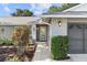Exterior shot shows brick accents, lush landscaping and a sidelight at the front door at 15917 Hidden Lake Cir, Clermont, FL 34711