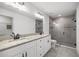 A bright bathroom offers a double vanity with granite countertops and a tiled walk-in shower at 16062 Se 89Th Ter, Summerfield, FL 34491