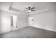 Spacious bedroom with neutral gray carpeting and doorways leading to the en suite bathroom and walk-in closet at 16062 Se 89Th Ter, Summerfield, FL 34491