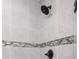 Close up of tiled shower with mosaic accents and bronze hardware at 16062 Se 89Th Ter, Summerfield, FL 34491