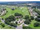 Expansive aerial view of the golf course community with lush green fairways, serene pond, and well-maintained homes at 17233 Se 115Th Terrace Rd, Summerfield, FL 34491