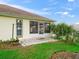 A screened-in back patio with tiled flooring overlooks a grassy backyard, perfect for relaxing outdoors at 17233 Se 115Th Terrace Rd, Summerfield, FL 34491