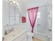Bathroom featuring tub with red shower curtain, single sink vanity, and standard toilet at 17233 Se 115Th Terrace Rd, Summerfield, FL 34491