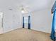 Bedroom featuring neutral carpet, ceiling fan, large closet, and window with dark blue curtains at 17233 Se 115Th Terrace Rd, Summerfield, FL 34491