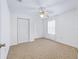 Bedroom with carpeted floor, ceiling fan, neutral paint, closet, and window with sheer curtains at 17233 Se 115Th Terrace Rd, Summerfield, FL 34491