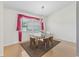 Bright dining room with hardwood floors, modern light fixture, and a large window with decorative curtains at 17233 Se 115Th Terrace Rd, Summerfield, FL 34491