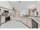 Modern kitchen featuring updated appliances, light cabinetry, and views of the living and dining areas at 17233 Se 115Th Terrace Rd, Summerfield, FL 34491