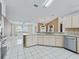 Spacious kitchen with stainless steel appliances, light countertops, white tile floors and a view to the living room at 17233 Se 115Th Terrace Rd, Summerfield, FL 34491