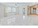 Spacious living room featuring tile flooring, a ceiling fan, and access to the patio at 17233 Se 115Th Terrace Rd, Summerfield, FL 34491