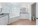 Bright main bathroom featuring a garden tub, vanity with granite counters, and tile floors at 17233 Se 115Th Terrace Rd, Summerfield, FL 34491