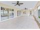 Spacious sunroom with tiled floors, neutral paint, and ceiling fans, offering great natural light at 17233 Se 115Th Terrace Rd, Summerfield, FL 34491