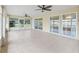 Large sunroom with tiled floors, neutral paint, and ceiling fans with views of backyard at 17233 Se 115Th Terrace Rd, Summerfield, FL 34491