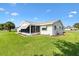 Lush backyard featuring the home's exterior with a screened-in porch and well-maintained landscaping at 17576 Se 96Th Ct, Summerfield, FL 34491