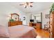 Comfortable bedroom with wooden floors, a large dresser, and a cozy rocking chair at 17576 Se 96Th Ct, Summerfield, FL 34491
