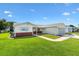 Well-maintained home featuring a spacious front yard and a welcoming, accessible walkway at 17576 Se 96Th Ct, Summerfield, FL 34491
