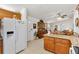 Kitchen with granite counters, wooden cabinetry, tile floors, adjacent to breakfast nook and living space at 17576 Se 96Th Ct, Summerfield, FL 34491