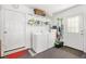 Functional laundry room with washer, dryer, storage shelves, and convenient access to the outside at 17576 Se 96Th Ct, Summerfield, FL 34491