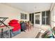 Covered porch with tile flooring featuring red cushions and a grill; ideal for outdoor relaxing at 17576 Se 96Th Ct, Summerfield, FL 34491