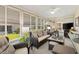 Bright sunroom featuring wicker furniture, plush cushions, and multiple windows offering ample natural light at 17576 Se 96Th Ct, Summerfield, FL 34491