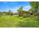 The backyard has a grassy lawn, mature trees, and a cozy patio area, blending nature with outdoor living at 1852 Ne 39Th Ct, Ocala, FL 34470