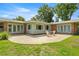 A charming patio with a table and chairs complements the brick and siding exterior in the spacious backyard at 1852 Ne 39Th Ct, Ocala, FL 34470