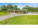 Beautiful home showcasing its expansive lawn, mature trees, and attached garage at 1852 Ne 39Th Ct, Ocala, FL 34470