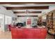 Bright living room featuring exposed beams, brick fireplace, and a front door view at 1852 Ne 39Th Ct, Ocala, FL 34470