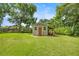 Charming backyard shed offers storage and features a rustic wooden door and a covered area for tools at 1852 Ne 39Th Ct, Ocala, FL 34470