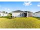 View of the house from the backyard with a screened porch and green lawn at 1875 Nw 44 Court Rd, Ocala, FL 34482