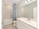 Well-lit bathroom featuring modern vanity, large mirror, ceramic tiled shower and blue and white shower curtain at 1875 Nw 44 Court Rd, Ocala, FL 34482