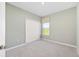 Carpeted bedroom with a double door closet, neutral walls, and a window with a decorative cornice at 1875 Nw 44 Court Rd, Ocala, FL 34482