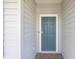 Close-up of the front door, a stylish blue with a modern door handle and smart lock, framed by gray siding at 1875 Nw 44 Court Rd, Ocala, FL 34482