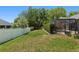 Spacious backyard with a screened-in pool area, a white vinyl fence, and mature landscaping for privacy and outdoor activities at 2010 Se 25Th St, Ocala, FL 34471