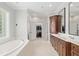 Bright bathroom with dual vanities, a soaking tub, and a view into the walk-in closet at 2010 Se 25Th St, Ocala, FL 34471