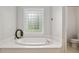Bright bathroom with a soaking tub under a window and a toilet at 2010 Se 25Th St, Ocala, FL 34471