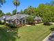 Landscaped front yard featuring lush green grass, mature trees, and stone accents, creating an inviting curb appeal for the home at 2010 Se 25Th St, Ocala, FL 34471