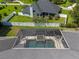 Aerial view of a screened-in pool and spa with a spacious patio, perfect for relaxation and outdoor entertaining at 2010 Se 25Th St, Ocala, FL 34471