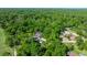 Aerial view of a home nestled in a lush, green landscape with a pool and detached garage at 20861 Sw 81St Loop, Dunnellon, FL 34431