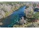 Breathtaking aerial view showcasing crystal-clear turquoise waters winding through lush Florida nature and tree canopies at 20861 Sw 81St Loop, Dunnellon, FL 34431