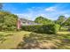 Sprawling, well manicured backyard with a large hedge in the middle of the yard at 20861 Sw 81St Loop, Dunnellon, FL 34431