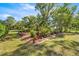 Green backyard with mulched area and wooden supports for plants and vines at 20861 Sw 81St Loop, Dunnellon, FL 34431
