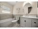 Bright bathroom featuring a tub, toilet, modern vanity with a round mirror, and tiled floor at 20861 Sw 81St Loop, Dunnellon, FL 34431