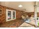 Comfortable covered patio with brick flooring, brick walls, skylights, ceiling fans, and outdoor dining area at 20861 Sw 81St Loop, Dunnellon, FL 34431
