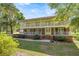 Charming two-story home with a brick facade, double balconies, and a well-manicured front lawn under a sunny sky at 20861 Sw 81St Loop, Dunnellon, FL 34431
