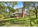 Expansive side view showcases a two-story home with brick accents, a covered balcony, and a well-maintained lawn at 20861 Sw 81St Loop, Dunnellon, FL 34431