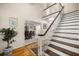 Inviting foyer showcases a staircase, hardwood floors, and a glimpse into the dining room, creating an elegant entrance at 20861 Sw 81St Loop, Dunnellon, FL 34431