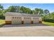 Three car garage with white doors and brick accents in the lower portion at 20861 Sw 81St Loop, Dunnellon, FL 34431